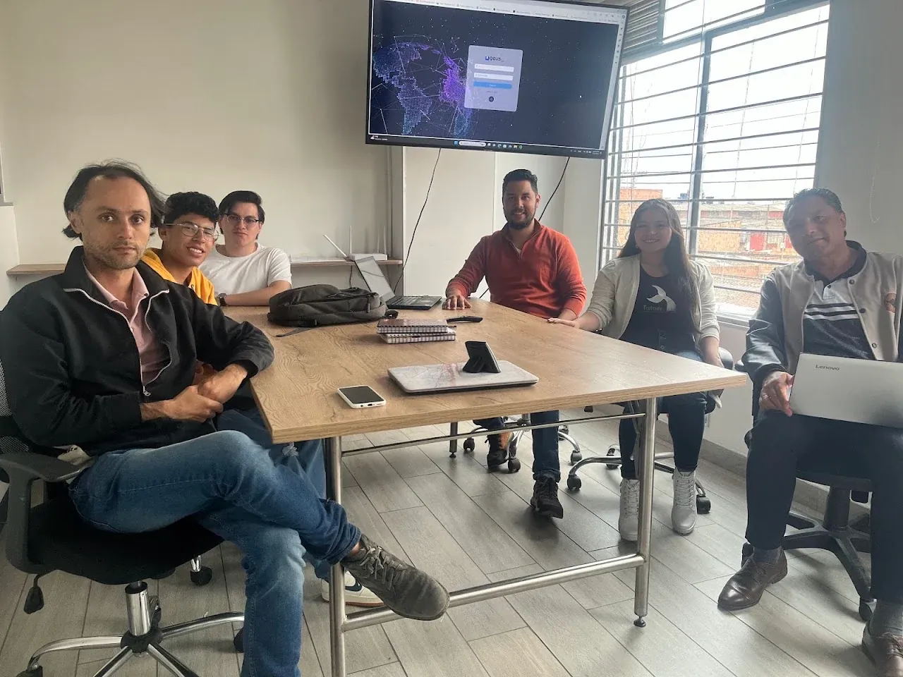 Equipo de Geus ISP reunido alrededor de una mesa de trabajo.